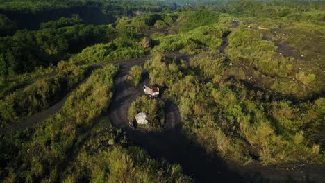 Aerial-view-of-trucking-arriving-at-sand-mine-in-forest-landscape-of-Merapi-Volcano-in-Central-Java---Environmental-catastrophe-destroying-growing-nature