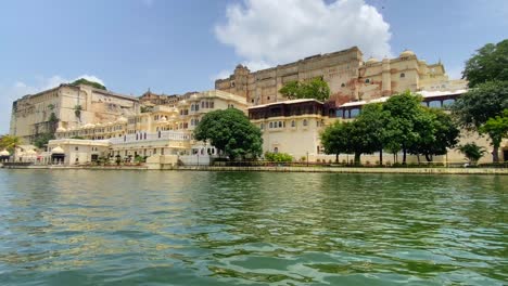 Sailing-Past-Udaipur-City-Palace-On-The-Bank-Of-Lake-Pichola-On-Clear-Sunny-Day