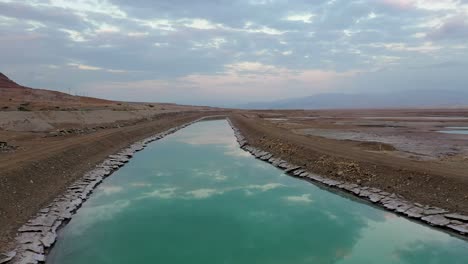 Israel,-Turkiz-color-channel-of-water-by-the-Deadsea,-Drone-shot-fly-over