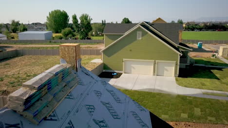 A-drone-shot-back-away-passing-a-newly-framed-house-with-shingles-ready-to-be-placed-on-top