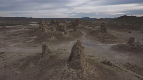 Drone-descending-over-an-otherworldly-landscape,-the-Trona-Pinnacles-in-California