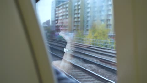 slide-shot-of-a-young-man-traveling-by-train-seen-in-the-reflection