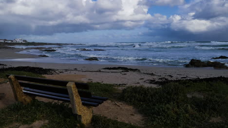 TimeLapse---Clouds-moving-across-frame,-view-over-ocean-with-bench-in-foreground