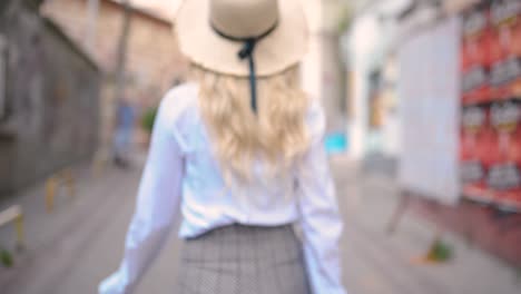 Attractive-young-beautiful-girl-with-hat-walks-and-discovers-places-in-narrow-street