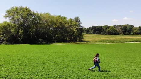Tracking-Shot-Of-A-Young-Girl-Running-Through-A-Rural-Field