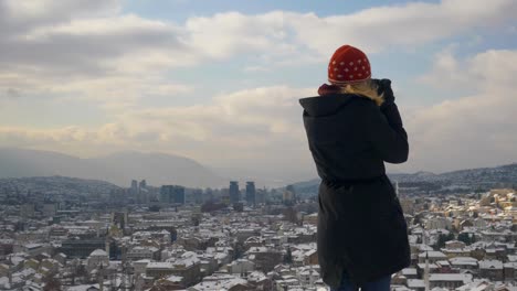 Mittlere-Aufnahme-Der-Rückansicht-Einer-Blonden-Frau,-Während-Sie-über-Die-Stadt-Sarajevo-Blickt