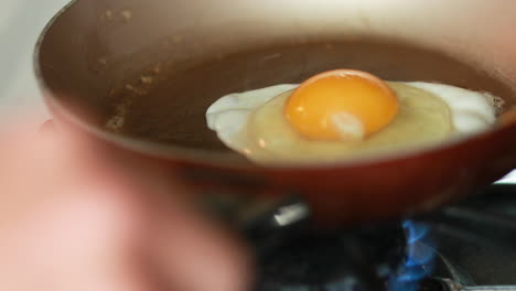Romper-Un-Huevo-En-Una-Sartén-Con-Mantequilla-Caliente-Para-Cocinar-Para-El-Desayuno