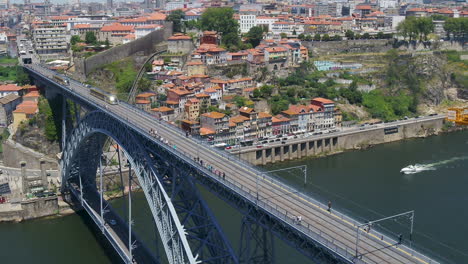 Imágenes-Aéreas-De-La-Orilla-Del-Río-Douro-Girando-Sobre-El-Puente-Dom-Luís-I-En-La-Ciudad-De-Porto,-Portugal