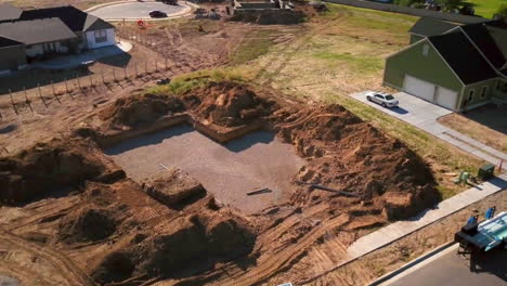 A-drone-shot-spinning-around-a-recently-dug-hole-for-the-starting-of-a-new-house-about-to-built