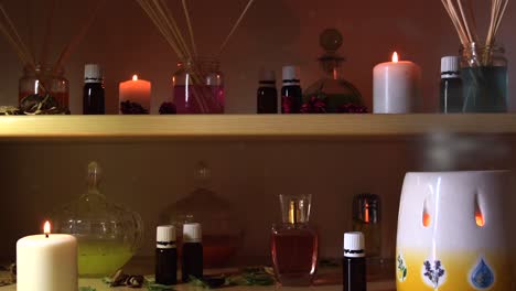 Parfümherstellungsraum-Mit-Vielen-Kerzen,-Flaschen-Und-Gläsern-Mit-Farbigen-Flüssigkeiten,-In-Der-Nähe-Eines-Dampfgarers-Mit-Austretendem-Dampf-Und-Herumfliegendem-Staub