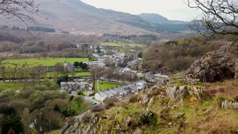The-village-of-Beddgelert---aerial-view-with-mountains-in-the-background,-Snowdonia,-North-Wales,-UK