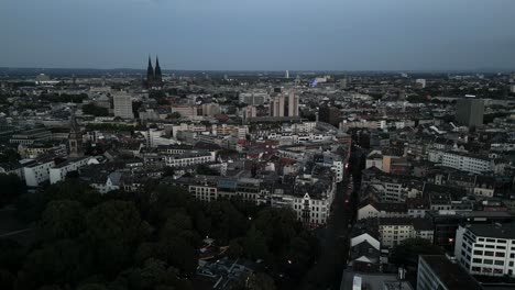 Cologne,-North-Rhine-Westphalia,-Germany---Descending-aerial-bird-drone-flight-of-the-panorama-silhouette-of-Köln-city-center-with-Dom-during-dawn-night-evening-seen-from-north-Ehrenfeld-in-2022