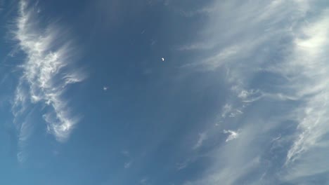 Vista-Del-Hermoso-Y-Misterioso-Cielo-Azul-Con-Nubes-Que-Se-Desvanecen-Y-Luna-Con-Movimiento-Lento-De-Cámara-De-Mano-A-Cámara-Lenta