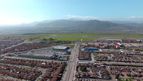 Boom-up-aerial-view-of-several-housing-complexes-next-to-La-Serena-airport-with-the-mountain-in-the-background,-Chile