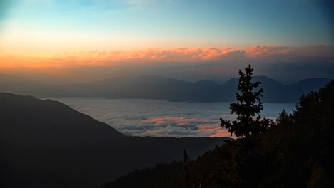 Time-lapse-of-mountains-covered-in-the-clouds-at-sunrise-in-the-morning-with-beautiful-colors-in-the-sky-and-the-sun-going-up-1