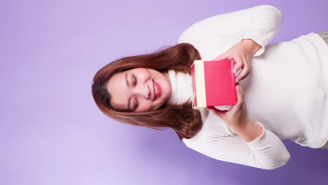 Vertical-Portrait-beautiful-of-Asian-happy-woman-holding-a-red-gift-box-standing-isolated-over-a-violet-background-3