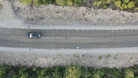 4k-Luftbild-Von-Oben-Auf-Ein-Auto,-Das-Auf-Einer-Unbefestigten-Straße-Durch-Den-Wald-Fährt