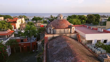 Aerial-approaching-shot-of-historic-cupola-of-Regina-Angelorum-Convent-Church-with-Ocean-in-background---Santo-Domingo,Dominican-Republic