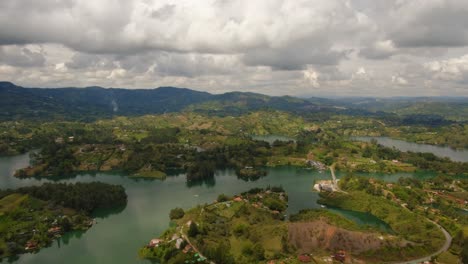 Cinematic-Time-Lapse-Aerial-Above-Guatape-Sun-Reflection-Green-Islets-Blue-Water-Medellin-Colombia-Piedra-del-Peñol-Top-Notch-Drone