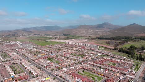 Panoramic-aerial-view-of-planned-streets-with-housing-complexes-among-the-misty-mountains