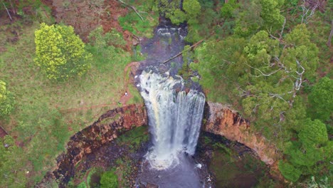 Rising-aerial-footage-of-water-flowing-over-the-Trentham-Falls-after-rain-on-22-Sepember,-2021,-Victoria,-Australia