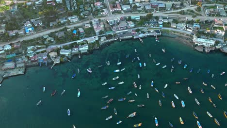 Aerial-view-of-Tongoy-bay-and-its-seabed-with-parked-boats-and-humble-houses-overlooking-the-sea,-Chile