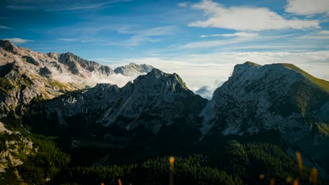 Timelapse-of-big-mountains-in-Slovenia-in-the-alps-with-clouds-coming-down-from-the-valley-and-over-the-mountains-at-sunny-weather