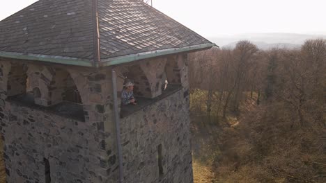 Male-caucasian-tourist-taking-photos-from-an-old-brick-observation-tower-during-a-sunny-winter-day
