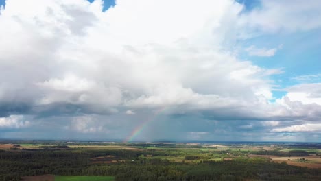 The-Rainbow-Over-the-Crop-Field-With-Blooming-Wheat,-During-Spring,-Aerial-View-Under-Heavy-Clouds-Before-Thunderstorm-2