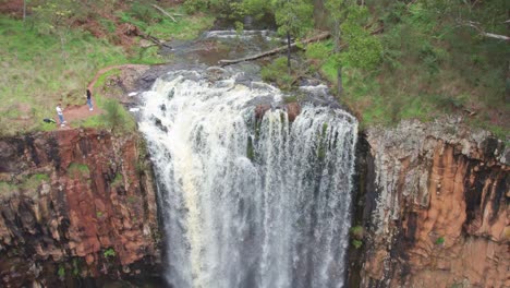 Panning-down-view-of-water-flowing-over-the-Trentham-Falls-after-rain-on-22-Sepember,-2021,-Victoria,-Australia