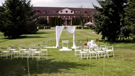 Altar,-arch-with-curtains-and-chairs-at-estate-wedding,-backward-dolly