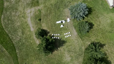 White-altar-and-chairs-between-trees-at-outdoor-wedding,-overhead-shot