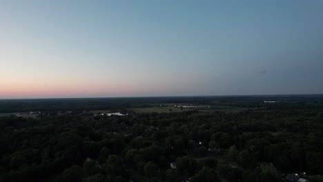 Drohne-Fängt-Den-Sonnenuntergang-Am-Horizont-Und-Die-Kleine-Stadt-Ohio-Ein,-Die-Von-Bäumen-Umgeben-Ist