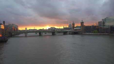 Kameraschwenk-Von-Der-London-Bridge-Mit-Blick-über-Die-Themse-Auf-Die-Berühmten-Denkmäler-Der-City-Of-London,-Darunter-Die-St.-Pauls-Cathedral-Und-Die-Blackfriars-Station-Bridge-Bei-Sonnenuntergang