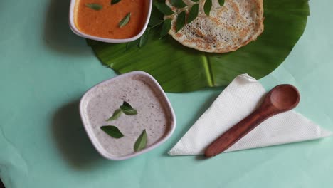 Set-Dosa-is-a-'set'-of-2-dosas-topped-with-butter-or-ghee-and-chutney-on-green-background