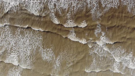 Top-down-view-of-the-waves-crashing-and-rising-up-as-the-sequence-progresses