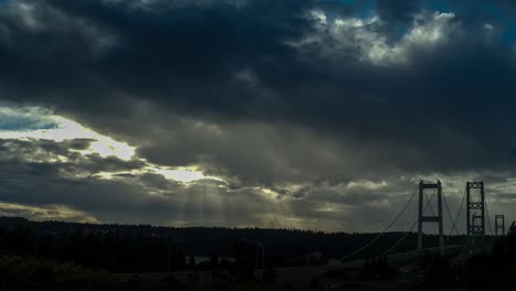 Zeitraffer-Des-Sonnenuntergangs-über-Der-Tacoma-Narrows-Brücke,-Dramatischer-Himmel,-Sonnenstrahlen
