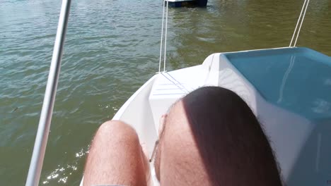 POV-male-hairy-feet-kicking-paddleboat-on-lake