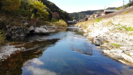Kleines-Dorf-In-Den-Bergen,-Durch-Das-Im-Herbst-Ein-Fluss-Fließt