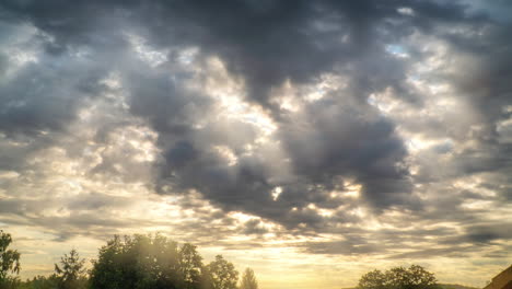 Timelapse-of-dawn-with-moving-heavy-clouds-and-golden-lightrays-breaking-through