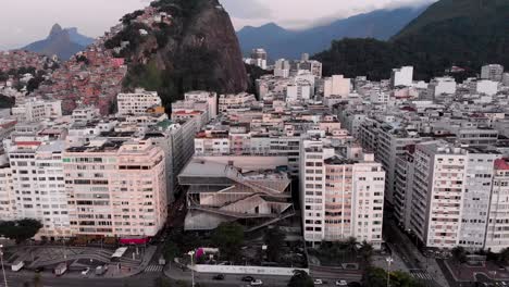 Aufwärtsbewegung-Aus-Der-Luft-Mit-Nach-Unten-Geneigter-Kamera,-Die-Das-Copacabana-Viertel-In-Rio-De-Janeiro-Am-Frühen-Morgen-Mit-Der-Skyline-Der-Stadt-Im-Hintergrund-Zeigt