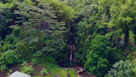 A-couple-sitting-at-the-base-of-an-epic-waterfall-in-the-rainforest-of-the-spice-island-Grenada