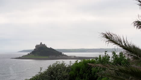 View-from-a-terrace-in-Marazion-of-the-english-medieval-castle-and-church-of-St-Michael's-Mount-in-Cornwall-on-a-cloudy-spring-day