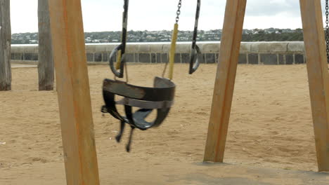 Empty-rubber-toddler-swing-at-a-coastal-playground