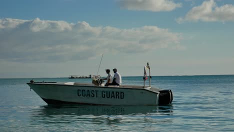 Two-coastguards-on-a-speedboat-passing-slowly-at-afternoon-light