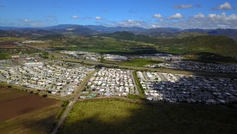 Droning-a-subdivision-in-Puerto-Rico-with-the-mountains-in-the-background-on-a-sunny-day