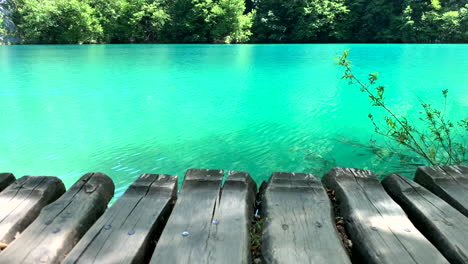 View-from-the-wooden-walkway-on-the-green-clear-water-with-fish-in-the-Plitvice-lake-in-Croatia