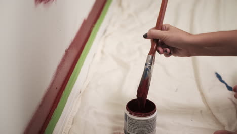 Young-woman-paints-red-wall-in-house