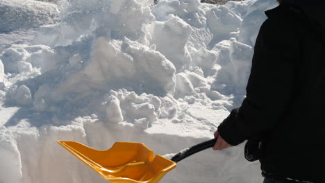 Close-up-of-man-shoveling-snow-off-a-trench