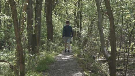 Man-walking-along-forest-footpath